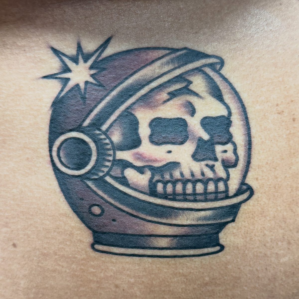 Black and gray astronaut skull tattoo with dense shading