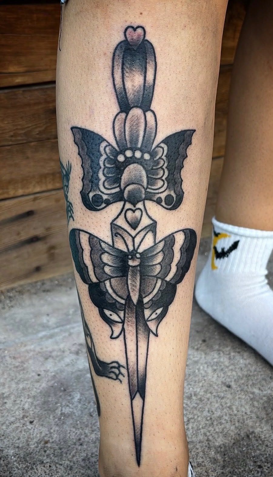 Black and gray butterfly dagger tattoo with fine line details