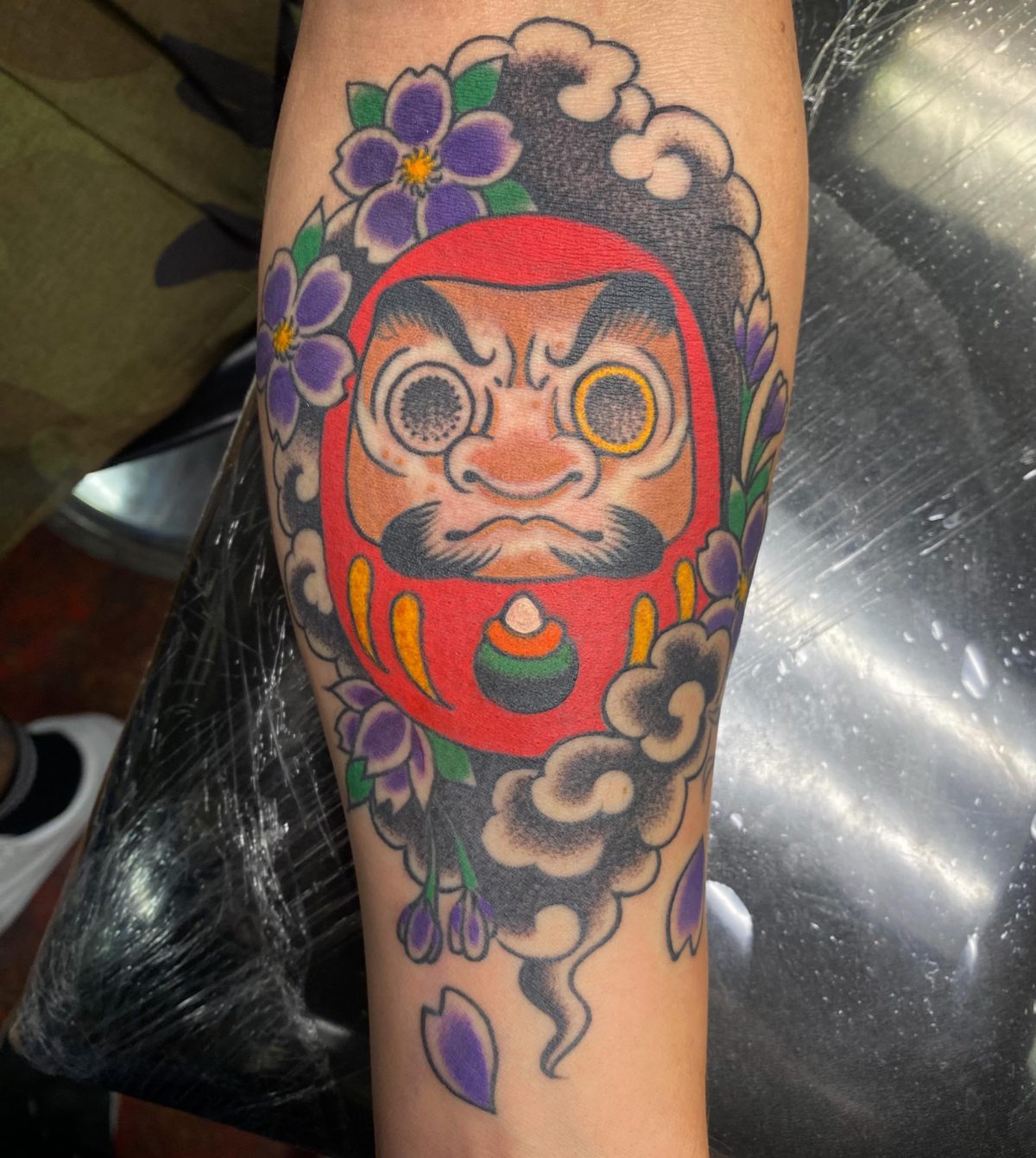 Traditional Daruma flash-style tattoo in red and black